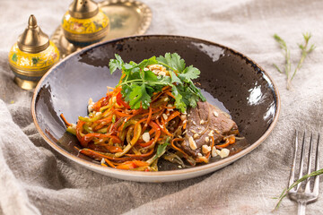 Spicy Beef asian style salad with carrot and cilantro on the table