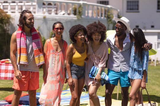 Diverse group of friends embracing and smiling at a pool party