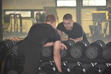 Fototapeta na wymiar Fitness Center Trainer Mann Hantel Training