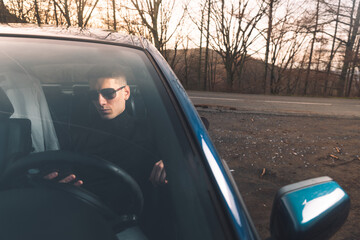 Fototapeta na wymiar Young caucasian man inside a car using a smartphone
