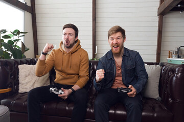 Men play game console and emotionally rejoice at victory, fun time at home