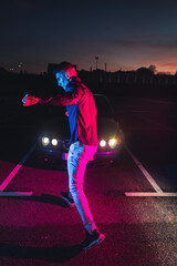 Young man with a sports car at a parking lot with color lights © Jorge Argazkiak