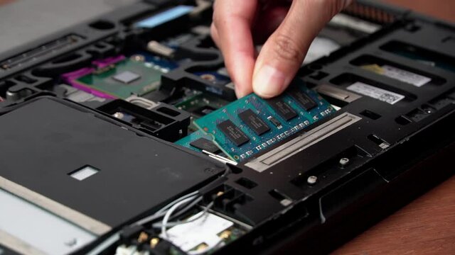 Laptop repair engineer (PC computer) and motherboard install RAM in computer lab top.	
