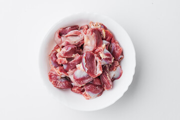raw chicken thighs on a white plate on a white background. Photo for clipping