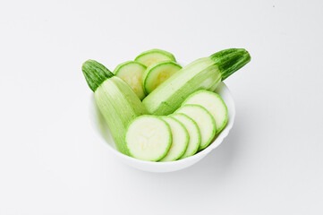 Raw sliced zucchini in a white plate on a white background. photo for clipping. Close-up