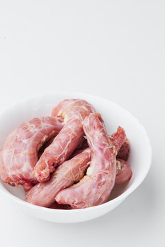 raw chicken necks on a white plate on a white background. Photo for clipping
