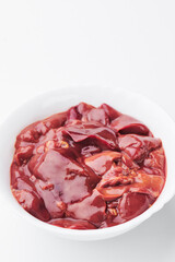 raw chicken liver in a white plate on a white background. Close-up. photo for clipping.