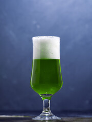 Green Irish traditional beer on St. Patrick's Day. A glass of beer on the dark table. copy space