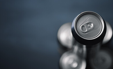 Aluminum cans for beer, soda, energy cocktails on a dark background, top view and copy space