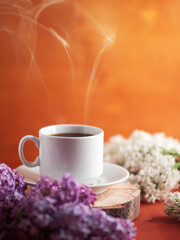Spring breakfast, good morning with a cup of hot coffee on the wooden, blooming lilac branches copy space