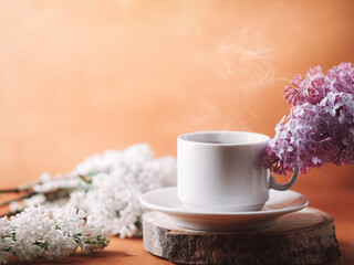 Fototapeta na wymiar Spring breakfast, good morning with a cup of hot coffee on the wooden, blooming lilac branches copy space