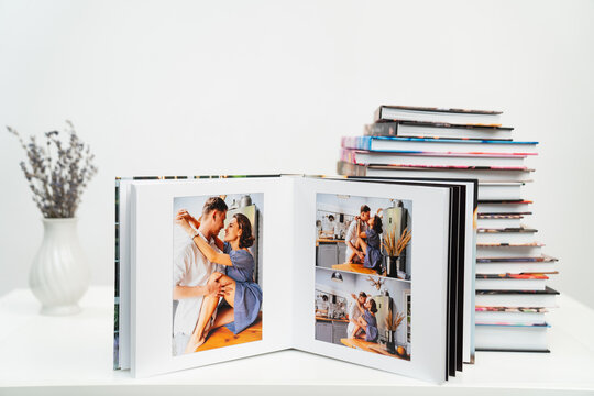 stack of books. open photobook from photo shoots of a beautiful happy couple