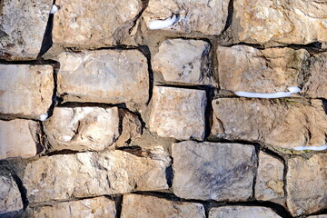 A wall made of gray stones. The old, ruined walls. History, travel, open space. Horizontal frame. Back background