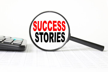 words SUCCESS STORIES in a magnifying glass on a white background. business concept