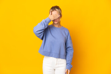 Young Russian woman isolated on yellow background covering eyes by hands. Do not want to see something