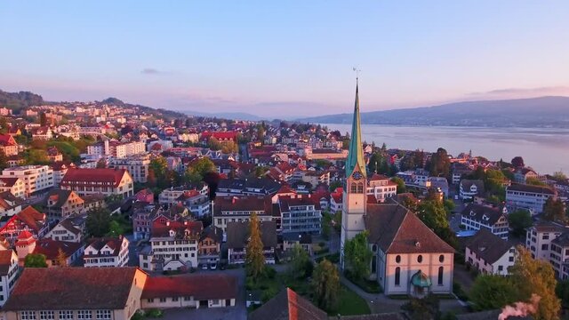 Buildings around the Reformed Church and Lake Zurich in the distance in W&auml;denswil, Horgen, Zurich, Switzerland; taken by a drone flying forward