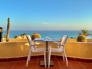 A set table on a terrace with a view of the sea. Concept: Vacation on Fuerteventura