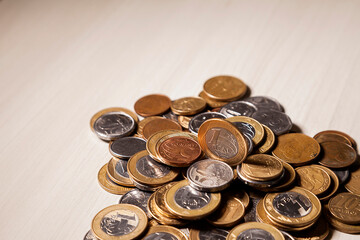 Pot with real currency, money from Brazil. Coins in the pot on the table. Brazilian economy, investments, income. Brazilian currency concept. Piggy bank concept.

