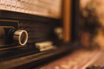 Old radio at home. Antique on a wooden table with hand-sewn tablecloth underneath.