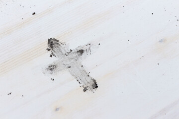 Ash cross on white wood background with copy space
