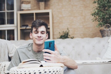 young man sitting on sofa has phone