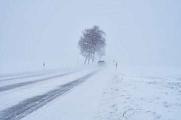 Autos auf Schneebedeckte Straße bei Schneesturm im Winter