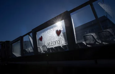 Foto auf Acrylglas Stay healthy. Blijf gezond. Hearts. Text on frozen window. Winter. Frost. Sunlight on window. Julianadorp Northsea coast Netherlands. Backlight. © A