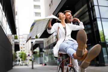 Fototapeta na wymiar Beautiful happy couple in love on bicycle in the city having fun