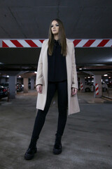 Obraz premium Outdoor portrait of young stylish woman in camel coat in the city on a rainy day