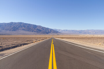 An empty road running straight through Death Valley National Park.