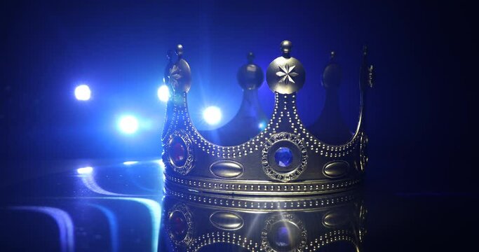 low key image of beautiful queen/king crown over wooden table. vintage filtered. fantasy medieval period. Selective focus. Colorful backlight