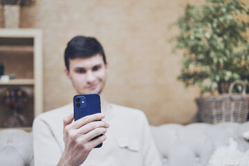 Video chat via smartphone, phone in hands of young man