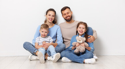 Happy parents with kids sitting in empty room