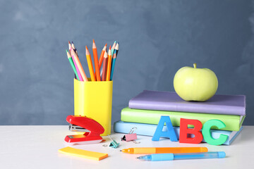 Fototapeta premium Apple and different school stationery on white wooden table