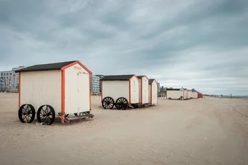 Gordijnen Rij traditionele strandcabines tegen grijze lucht © Erik_AJV