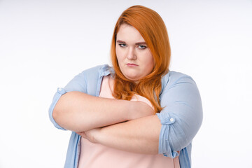 Offended plump redhead woman in casual clothing isolated over white background