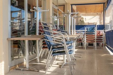 Metal chairs and tables stacked outdoor. Coronavirus crisis