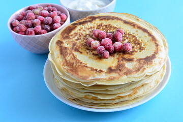 blini on the white plate  with frozen wild strawberries