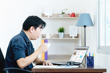 Businessman Checking Online News On Laptop with coffee in the morning