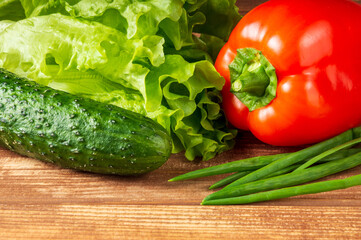 Set for making salad of fresh herbs, cucumbers and red pepper on a vintage table close up