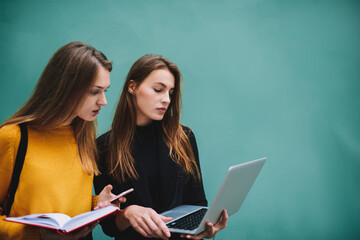 Pensive female students looking at laptop screen