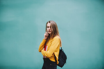 Pensive woman with backpack talking on phone
