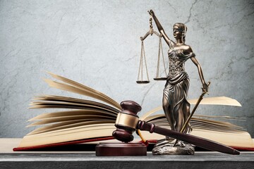 Closeup of a sculpture of Themis, book and gavel, symbol of justice