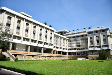 Fototapeta premium Ho Chi Minh City, Vietnam - Jan 4 2020: Backside view of the infamous Independence Palace in Saigon with an architecturally unique facade and palm trees on the roof