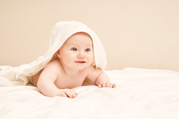 Cute small boy lying at bed. Childhood bath concept. Light background. Smiling child. Happy emotion. Copyspace. Stay home. Towel mockup