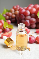 Natural grape seed oil and fresh berries on light table. Organic cosmetic