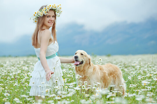 Lifestyle photo of a happy young girl with her pet dog Labrador Retriever in nature. High quality photo.