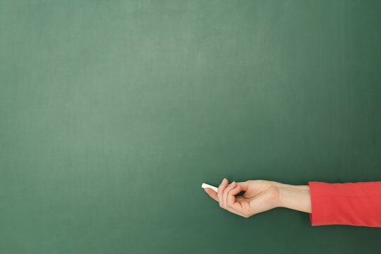 English teacher near green chalkboard at lesson, closeup
