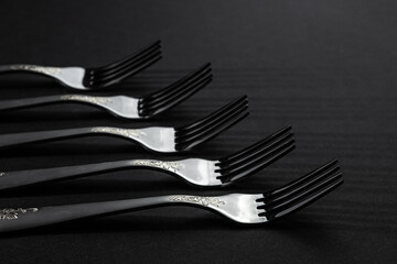 Plugs on a black background. Black and white photography. The shadow of the forks falls to the surface