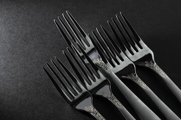 Plugs on a black background. Black and white photography. The shadow of the forks falls to the surface